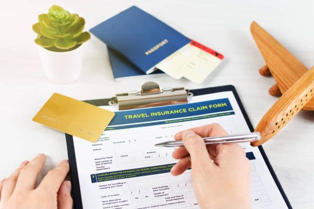 A traveler filling out an insurance claim form with bills.